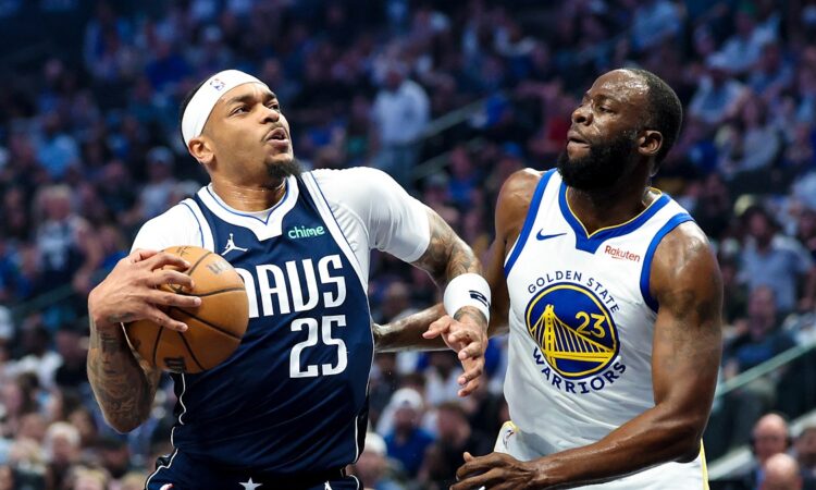 Dallas Mavericks forward P.J. Washington gathers the ball to drive as Golden State Warriors forward Draymond Green defends.