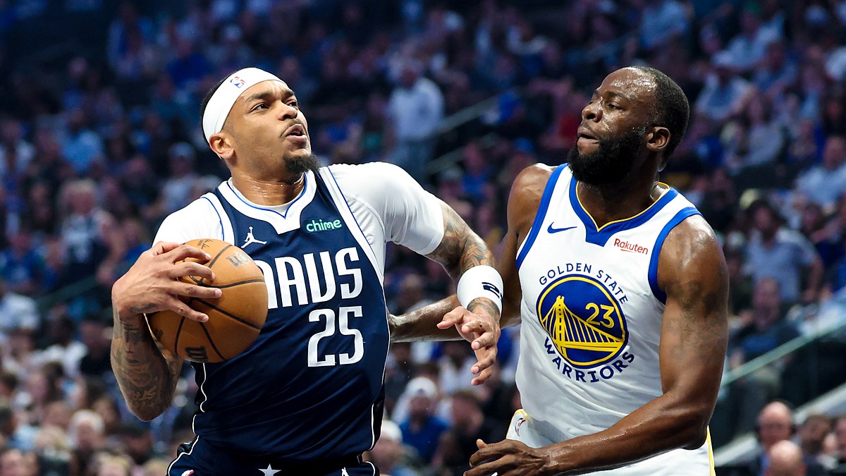 Dallas Mavericks forward P.J. Washington gathers the ball to drive as Golden State Warriors forward Draymond Green defends.