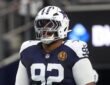 Dallas Cowboys defensive tackle Quinnen Williams stands in full pads during pregame warmups at AT&T Stadium.