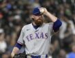 Texas Rangers pitcher Robby Ahlstrom holds the ball up near his cap on the mound in a gray road uniform.