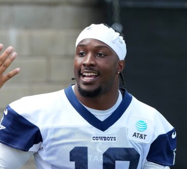 Dallas Cowboys wide receiver Ryan Flournoy smiles as he talks with fans reaching for autographs at training camp.