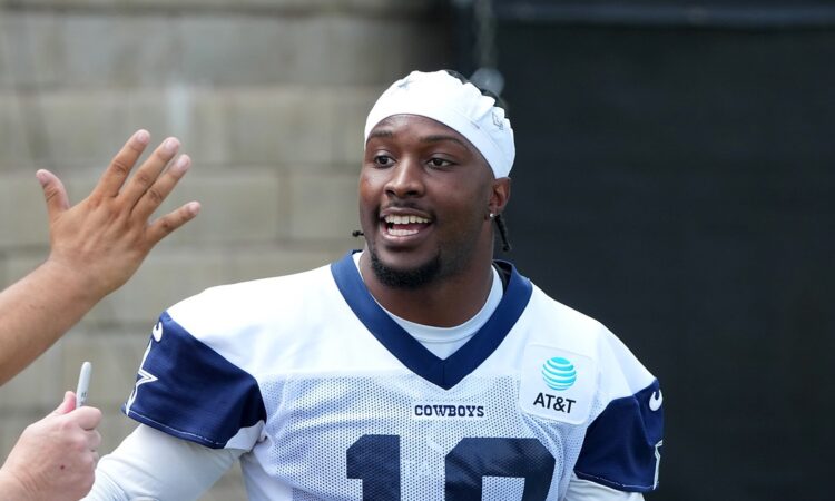 Dallas Cowboys wide receiver Ryan Flournoy smiles as he talks with fans reaching for autographs at training camp.