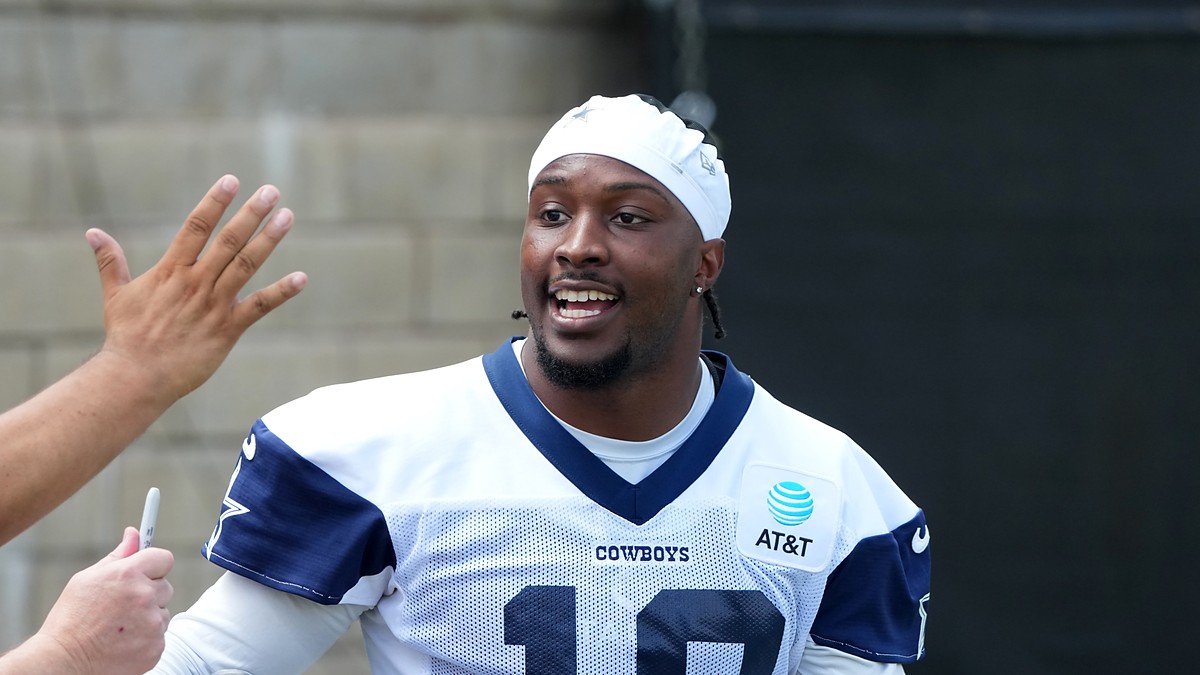 Dallas Cowboys wide receiver Ryan Flournoy smiles as he talks with fans reaching for autographs at training camp.