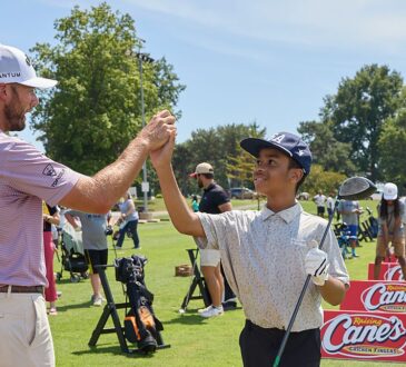 PGA Tour golfer Sam Burns clasps hands with a young golfer on the range at a First Tee and Boys and Girls Clubs event.