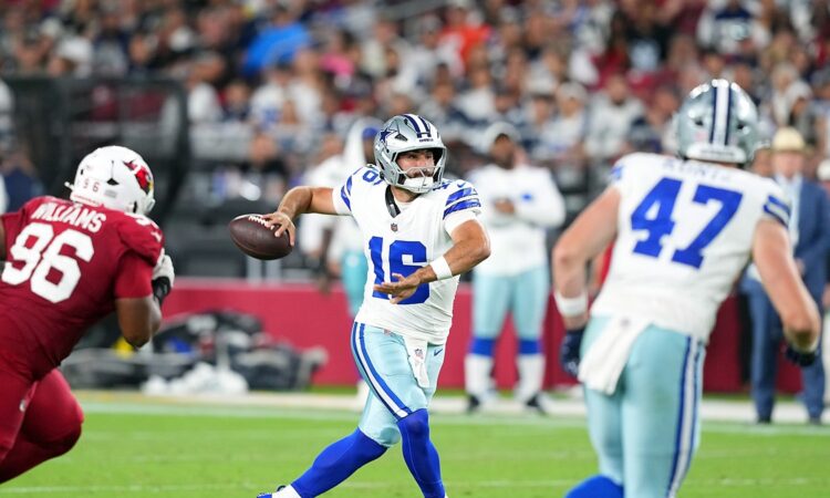 Dallas Cowboys quarterback Sam Howell throws downfield as a Cardinals lineman closes in.