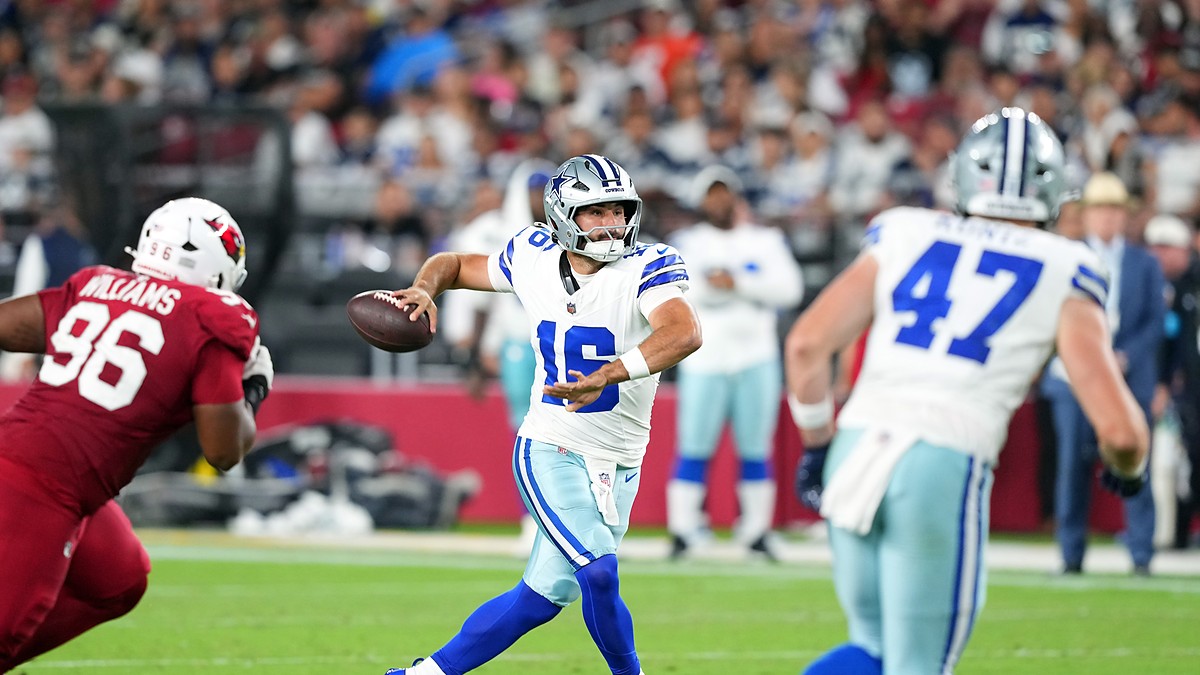 Dallas Cowboys quarterback Sam Howell throws downfield as a Cardinals lineman closes in.