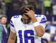 Alt Text: Dallas Cowboys quarterback Sam Howell runs a hand through his hair with his head down after the game.