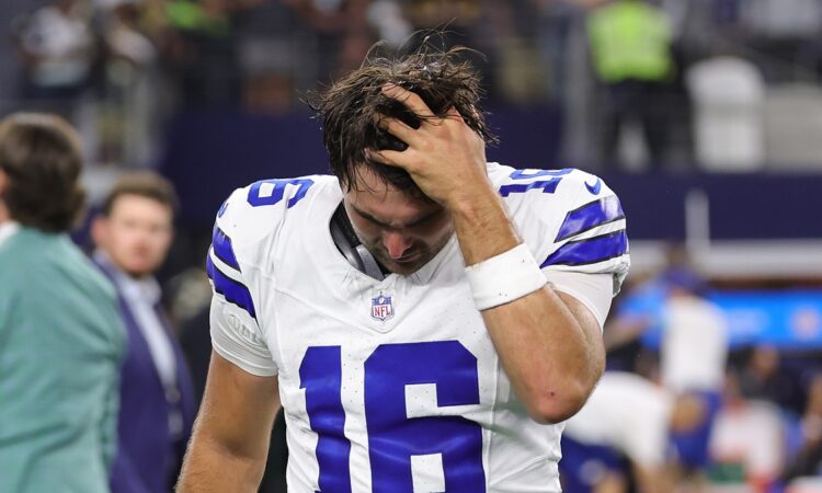 Alt Text: Dallas Cowboys quarterback Sam Howell runs a hand through his hair with his head down after the game.