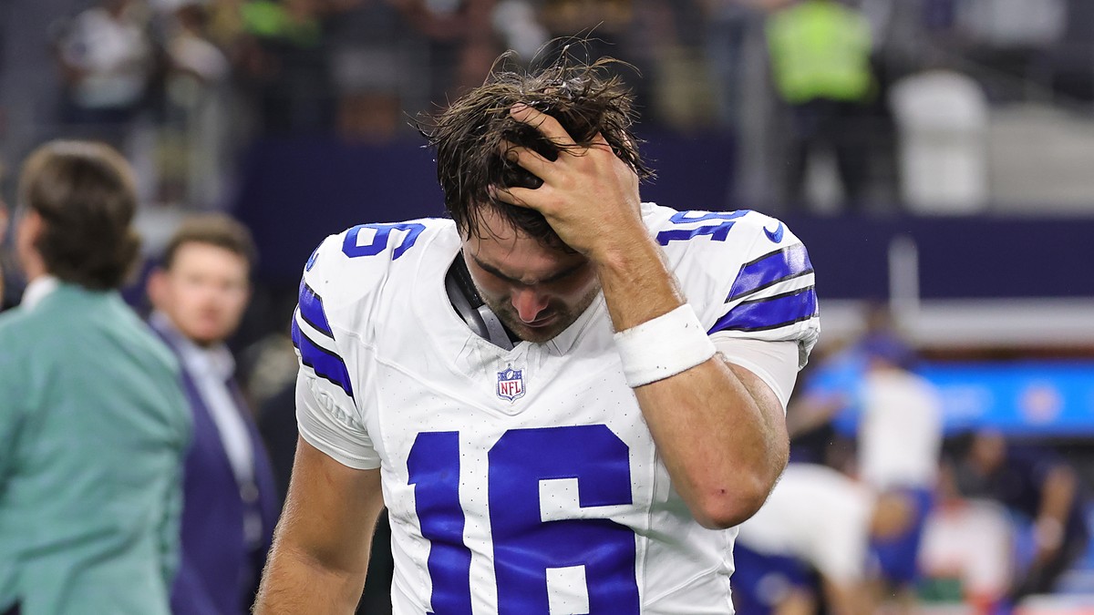 Alt Text: Dallas Cowboys quarterback Sam Howell runs a hand through his hair with his head down after the game.