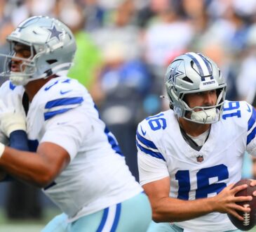 Dallas Cowboys quarterback Sam Howell holds the ball and scans downfield as a lineman blocks a Seattle Seahawks defender.