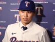 Texas Rangers two-way prospect Seong-Jun Kim speaks to reporters in a Rangers jersey and cap at Globe Life Field.