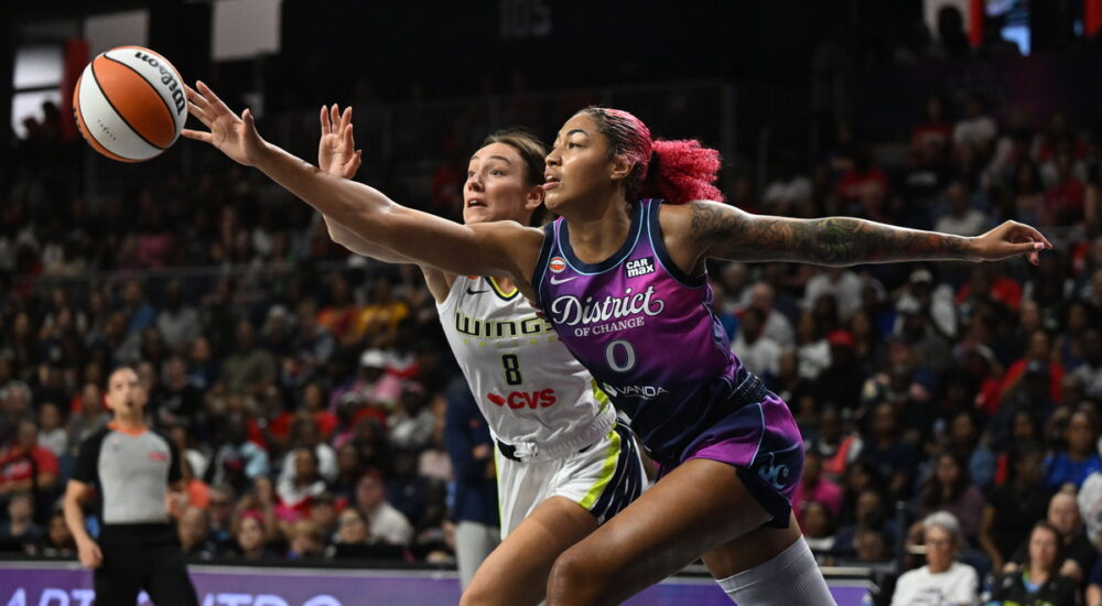 Washington Mystics center Shakira Austin and Dallas Wings forward Alanna Smith stretch for a loose ball.