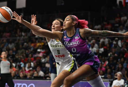 Washington Mystics center Shakira Austin and Dallas Wings forward Alanna Smith stretch for a loose ball.