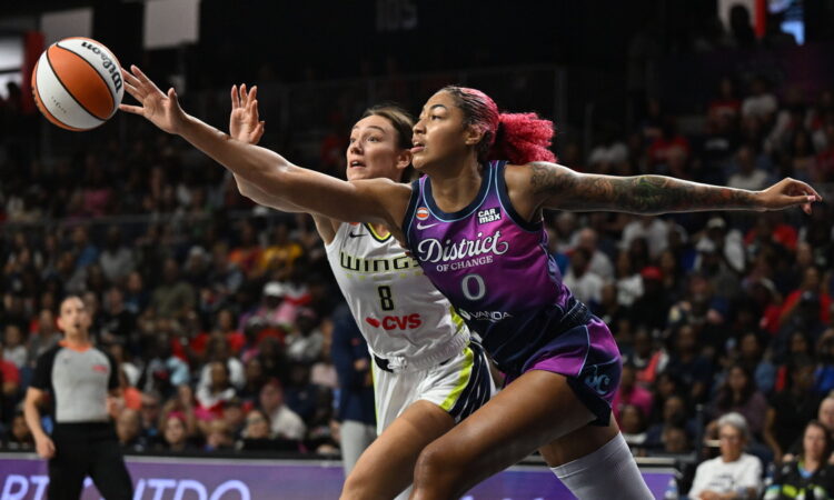 Washington Mystics center Shakira Austin and Dallas Wings forward Alanna Smith stretch for a loose ball.