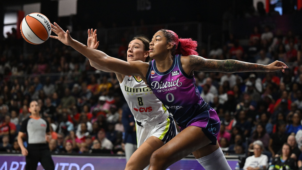 Washington Mystics center Shakira Austin and Dallas Wings forward Alanna Smith stretch for a loose ball.