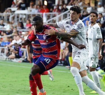 FC Dallas defender Shaq Moore holds off a Querétaro midfielder while dribbling along the touchline