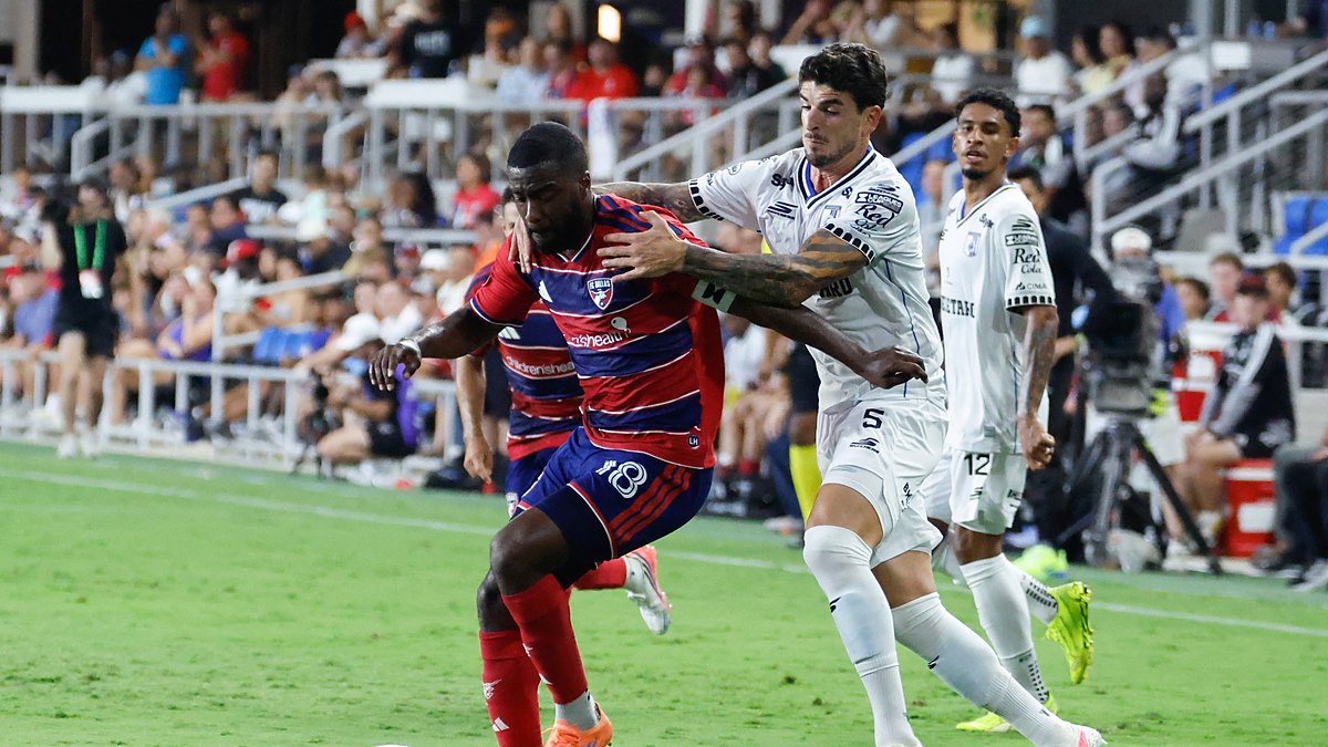 FC Dallas defender Shaq Moore holds off a Querétaro midfielder while dribbling along the touchline