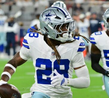 Dallas Cowboys cornerback Shavon Revel Jr. carries the ball upfield after an interception as teammates trail him.