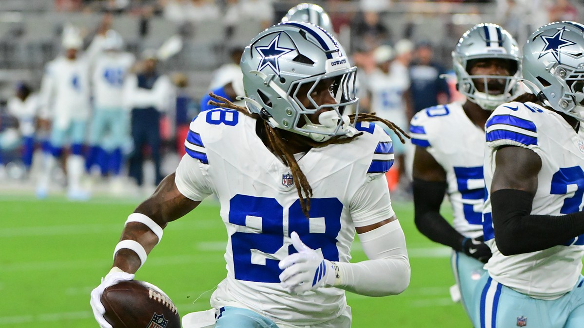 Dallas Cowboys cornerback Shavon Revel Jr. carries the ball upfield after an interception as teammates trail him.