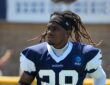 Dallas Cowboys cornerback Shavon Revel Jr. walks the practice field holding his gloves at training camp.