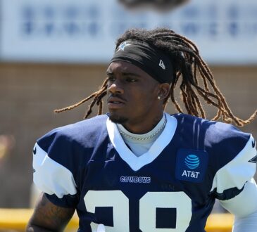 Dallas Cowboys cornerback Shavon Revel Jr. walks the practice field holding his gloves at training camp.