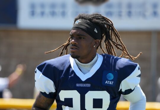 Dallas Cowboys cornerback Shavon Revel Jr. walks the practice field holding his gloves at training camp.
