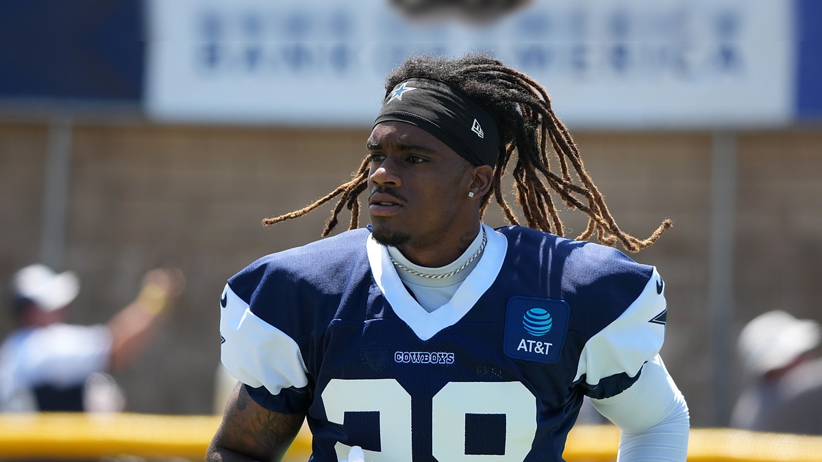 Dallas Cowboys cornerback Shavon Revel Jr. walks the practice field holding his gloves at training camp.