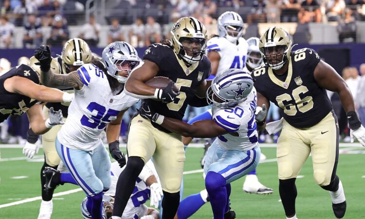Dallas Cowboys linebacker Shemar James wraps up New Orleans Saints running back Kendre Miller in the backfield.
