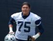 Dallas Cowboys offensive tackle Shiyazh Pete carries his helmet in a No. 75 practice jersey at training camp.