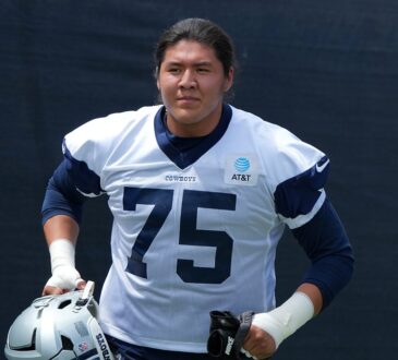Dallas Cowboys offensive tackle Shiyazh Pete carries his helmet in a No. 75 practice jersey at training camp.