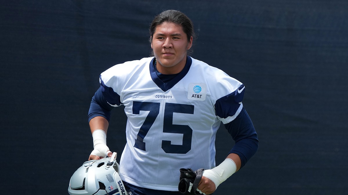 Dallas Cowboys offensive tackle Shiyazh Pete carries his helmet in a No. 75 practice jersey at training camp.