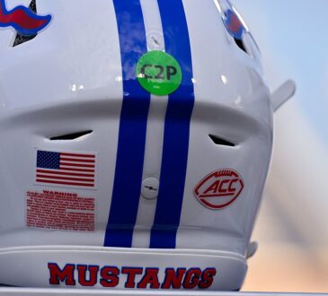 The red ACC logo decal on the back of a white SMU Mustangs football helmet with blue center stripes.