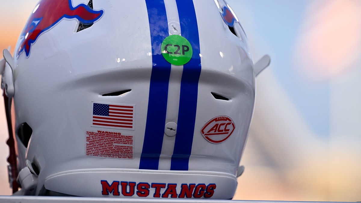 The red ACC logo decal on the back of a white SMU Mustangs football helmet with blue center stripes.