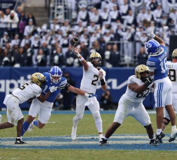 UCF Knights quarterback Tayven Jackson releases a pass under pressure from the BYU defense.