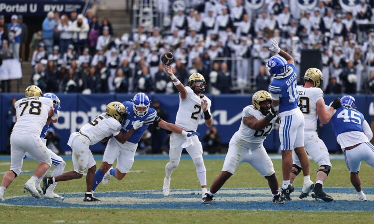 UCF Knights quarterback Tayven Jackson releases a pass under pressure from the BYU defense.