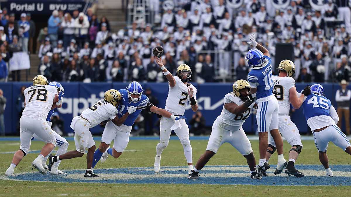 UCF Knights quarterback Tayven Jackson releases a pass under pressure from the BYU defense.