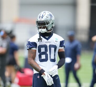 Dallas Cowboys wide receiver Traeshon Holden adjusts his gloves during a minicamp drill in his No. 80 practice jersey.