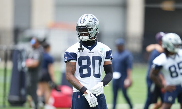 Dallas Cowboys wide receiver Traeshon Holden adjusts his gloves during a minicamp drill in his No. 80 practice jersey.