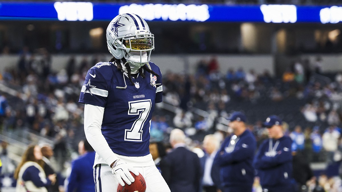 Dallas Cowboys cornerback Trevon Diggs stands with a football in his hand during pregame warmups in a navy No. 7 jersey.