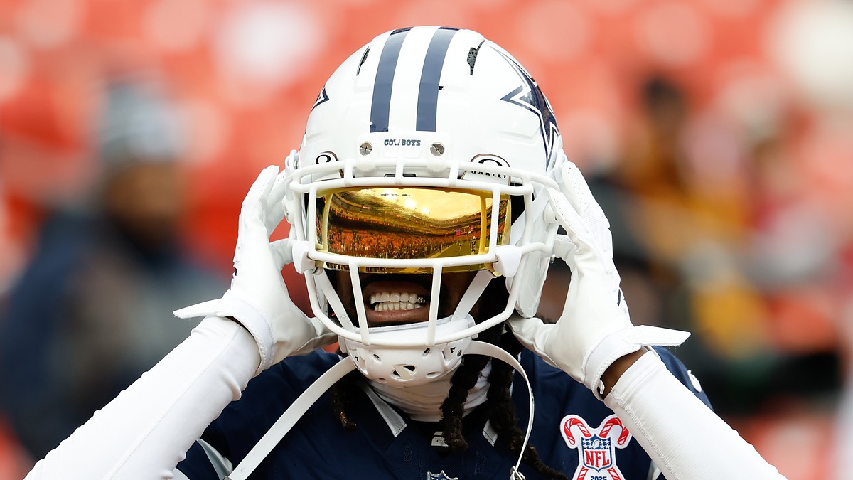 Dallas Cowboys cornerback Trevon Diggs adjusts his helmet during warmups, a gold visor covering his eyes.