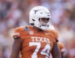 Texas Longhorns offensive lineman Trevor Goosby stands on the field in a burnt orange No. 74 jersey.