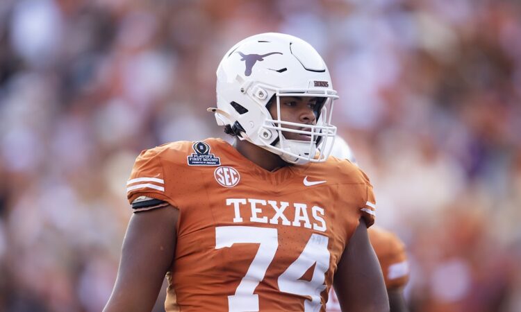 Texas Longhorns offensive lineman Trevor Goosby stands on the field in a burnt orange No. 74 jersey.