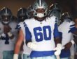 Dallas Cowboys offensive tackle Tyler Guyton wears No. 60 and walks through the stadium tunnel with teammates before kickoff.