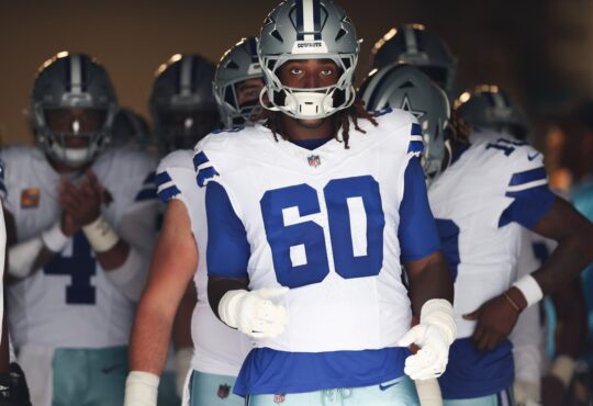 Dallas Cowboys offensive tackle Tyler Guyton wears No. 60 and walks through the stadium tunnel with teammates before kickoff.