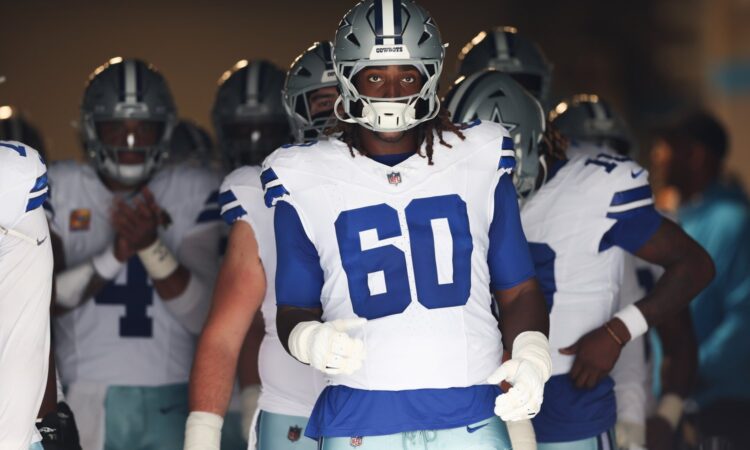 Dallas Cowboys offensive tackle Tyler Guyton wears No. 60 and walks through the stadium tunnel with teammates before kickoff.