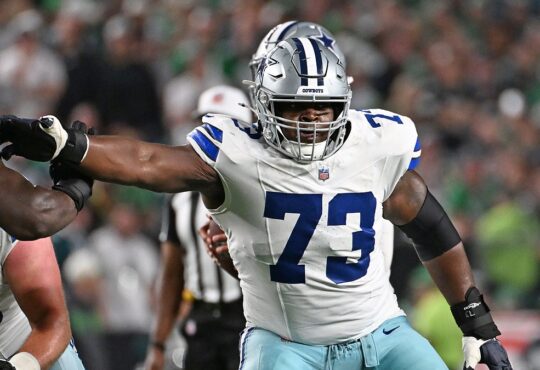 Cowboys guard Tyler Smith extends his arm to block an Eagles defender at the line of scrimmage