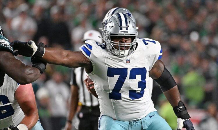 Cowboys guard Tyler Smith extends his arm to block an Eagles defender at the line of scrimmage