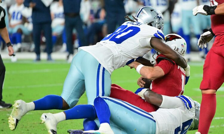 Dallas Cowboys linebacker Tyrus Wheat drives into Arizona Cardinals quarterback Gardner Minshew II as Minshew goes down.