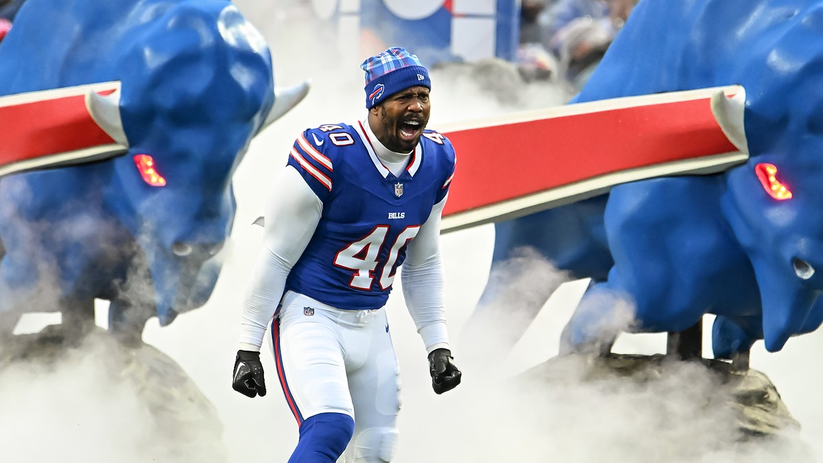 Buffalo Bills linebacker Von Miller shouts as he runs onto the field through smoke in a blue No. 40 jersey and knit cap.