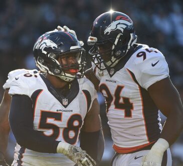 Denver Broncos outside linebacker Von Miller is congratulated by defensive end DeMarcus Ware on the field.